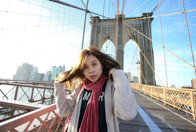 Portrait of beautiful young woman on suspension bridge