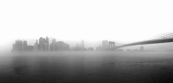 Brooklyn bridge over east river in foggy weather