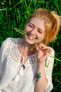 Portrait of young woman in grass field