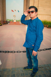 Full length of young man standing on footpath