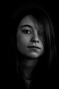 Portrait of a beautiful young woman over black background