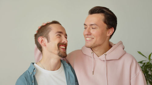 Portrait of smiling couple standing against white background