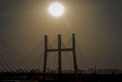 Silhouette of suspension bridge against sky during sunset