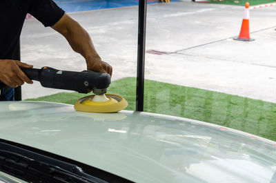 High angle view of man working with equipment on car in garage