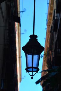 Low angle view of illuminated street light against blue sky