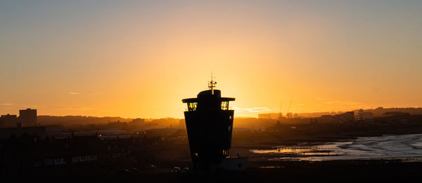 Silhouette of building against sky during sunset