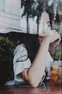 Midsection of woman drinking glass on table