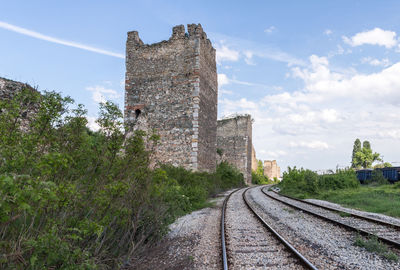 Railroad tracks by building against sky