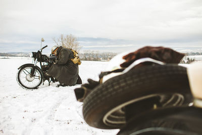 Man with motorcycle on snow against sky