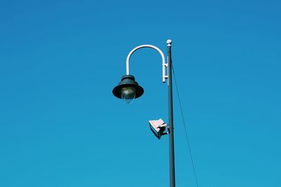 Low angle view of street light against blue sky