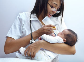 Nurse feeding baby with milk bottle