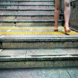 Low section of man standing on staircase