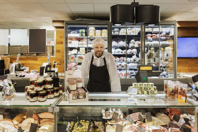 Portrait of smiling sales clerk standing in supermarket