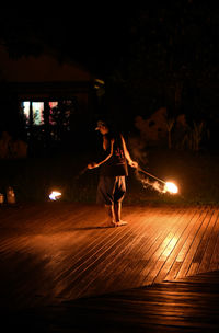 Rear view full length of fire dancer performing at night