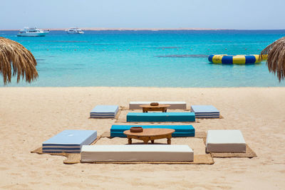 Seating arrangements at beach against sky on sunny day