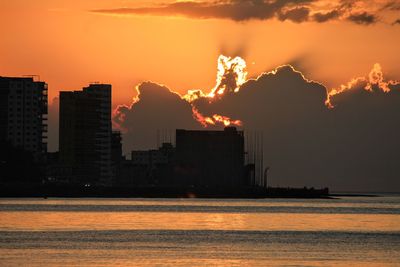 Silhouette buildings against sky during sunset