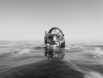 Close-up of swimming in sea against sky