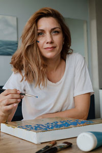 Closeup portrait of happy creative young woman smiling and looking directly to the camera during