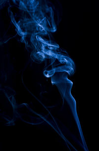 Close-up of blue smoke against black background