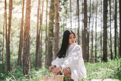 Woman crouching at forest