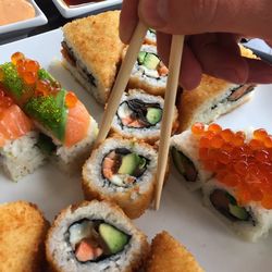 Cropped hand holding sushi served in plate