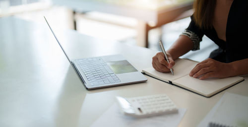 Midsection of businessman working at office