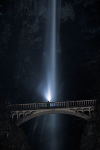 Bridge over river against sky at night