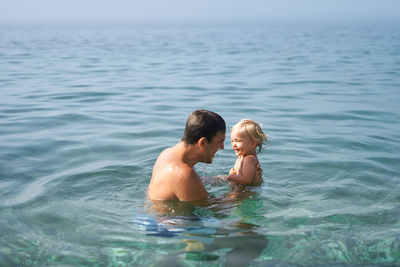 Rear view of boy swimming in sea