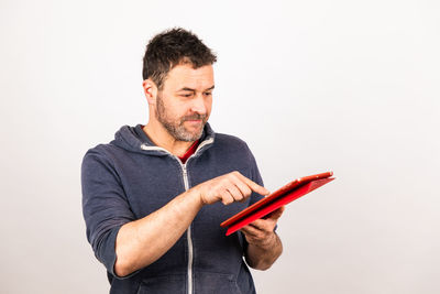 Man holding camera while standing against white background