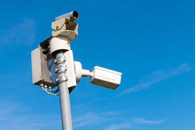 Surveillance cameras on a metal bar. against the background of the blue sky. closeup.