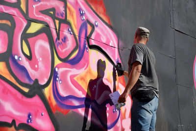 Rear view of man standing against wall