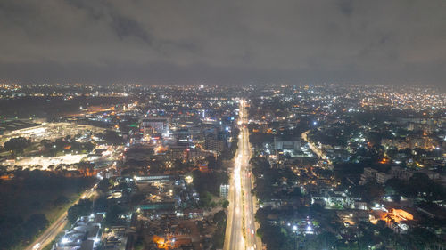 High angle view of illuminated city against sky at night