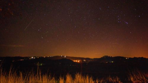 Scenic view of illuminated mountains against sky at night