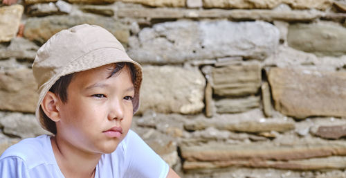 Portrait of boy looking away against wall