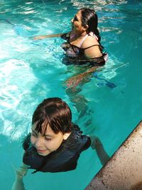 Mother and son swimming in pool