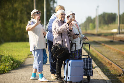 Group of senior women take a self-portrait on a platform waiting for a train 