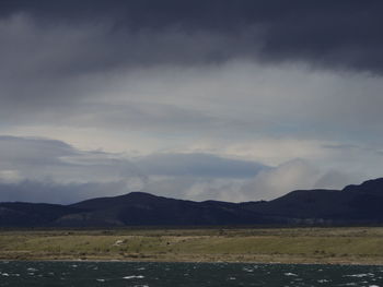 Scenic view of sea and mountains against sky