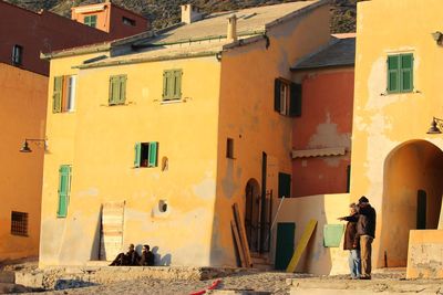 People in alley amidst buildings in city