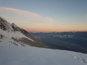 Scenic view of snowcapped mountains against sky during sunset