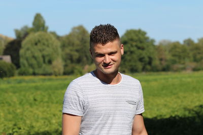 Portrait of young man standing on field