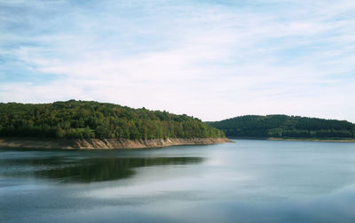Scenic view of lake by trees against sky
