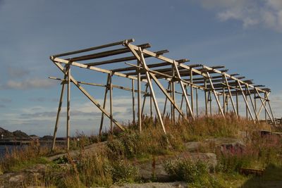 Low angle view of traditional windmill on field against sky