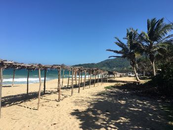 Scenic view of beach against clear blue sky