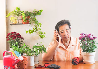 Young woman using phone while sitting on table