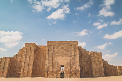 Low angle view of historical building against cloudy sky