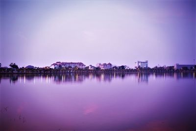 Scenic view of lake by buildings against sky