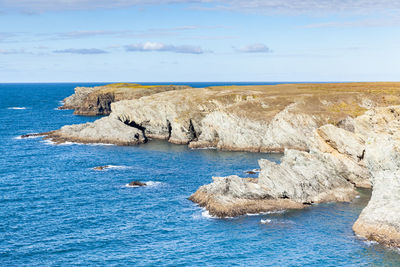 Scenic view of rocks in sea against sky