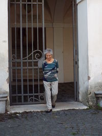Woman walking against metal gate