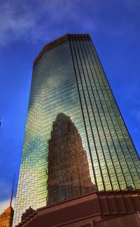 Low angle view of modern building against blue sky