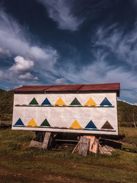 Multi colored houses on field against sky